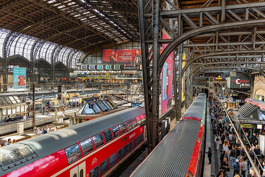 Hamburger Hauptbahnhof Der Hamburger Hauptbahnhof. Von oben sieht man das Treiben in der Bahnhofshalle mit roten Zügen und überfüllten Bahnsteigen.